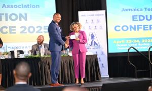 Minister of Education, Skills, Youth and Information, Senator Dr. the Hon. Dana Morris Dixon, accepts a donation form for a Critical Illness Trust Fund from President of the Jamaica Teachers' Association (JTA), Dr. Mark Smith, during day one (April 22) of a three-day JTA Education Conference 2025, being held at Ocean Coral Spring in Trelawny. Expansion and Upgrade of Labs in Technical High Schools Photo: Okoye Henry Minister of Education, Skills, Youth and Information, Senator Dr. the Hon. Dana Morris Dixon